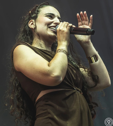 Leyh chante sur scène, un micro à la main