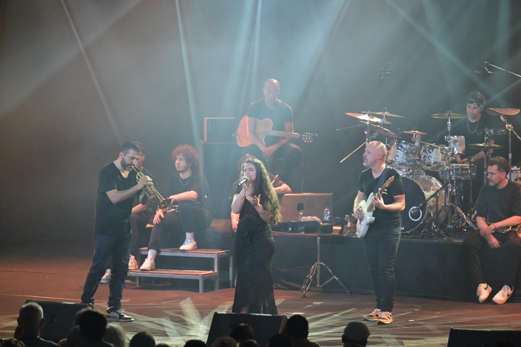 Leyh chante sur scène entourée de musiciens